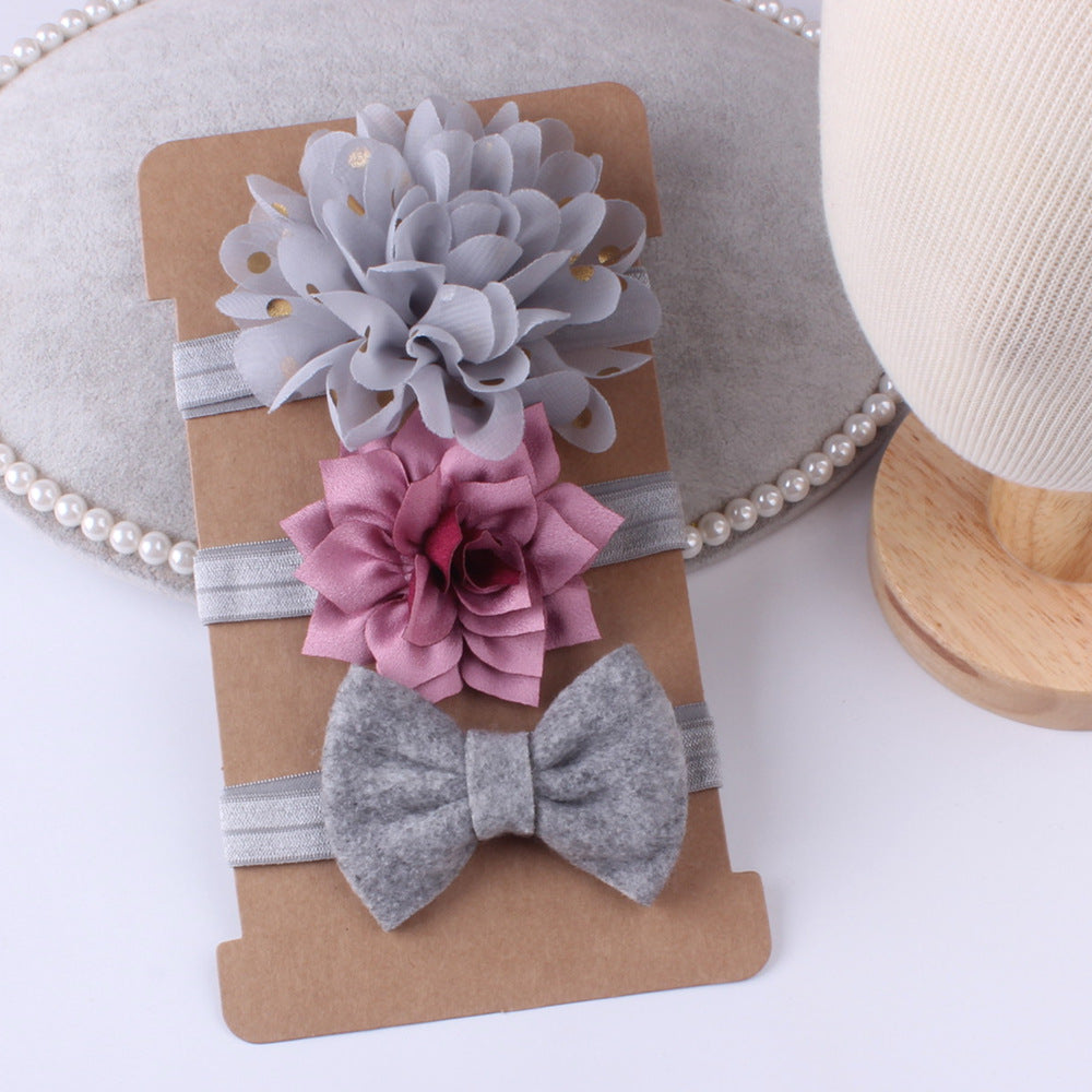 Floral and bow headbands on a cardboard stand with a white background