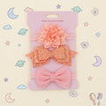 Set of pink hair accessories including a bow and a flower 