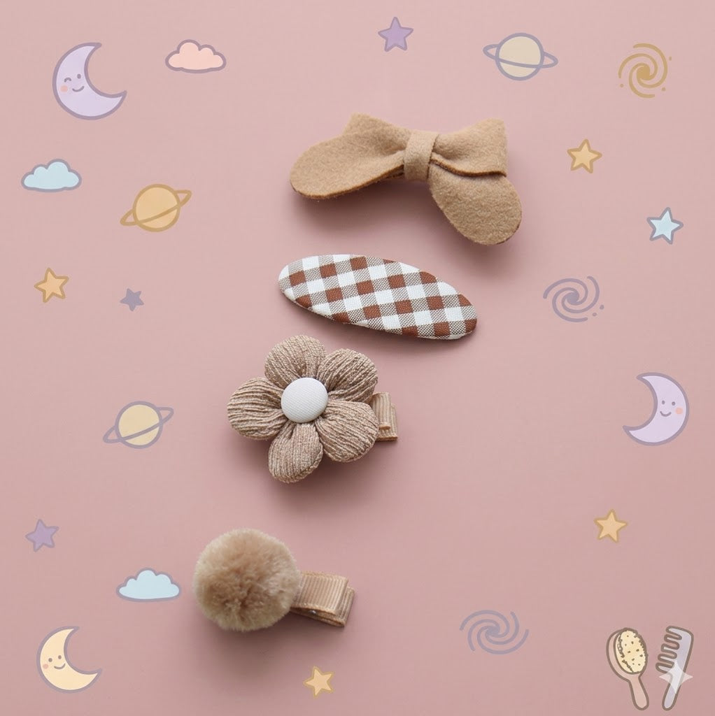 Set of five decorative hair clips on a pink background
