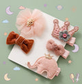Set of decorative hair accessories including bows and a crown 