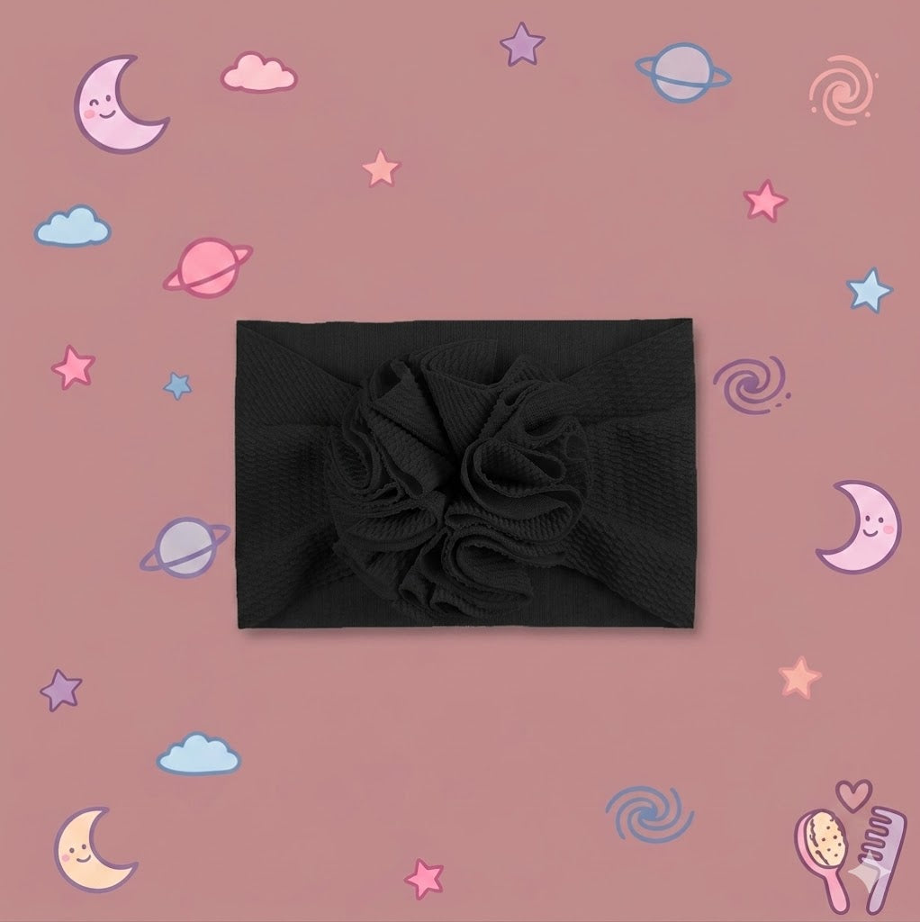 Black headband with a large flower on a pink background