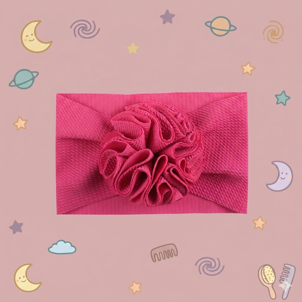 Pink headband with a flower accessory on a pink background