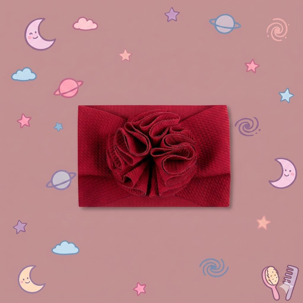 Red textured headband with a flower on a pink background